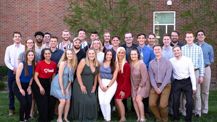 A group of people gathered together on a lawn for a group photograph.