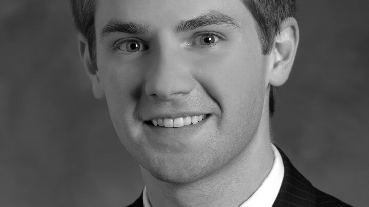 A black and white portrait of a man wearing a suit.