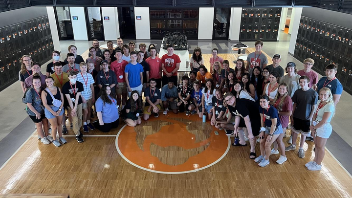 A large group of people assembled on a basketball court for a group photograph.