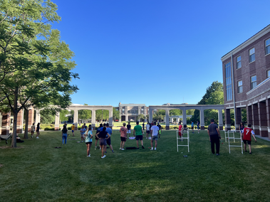 Students playing yard games in the Kauffman courtyard with clear blue skies