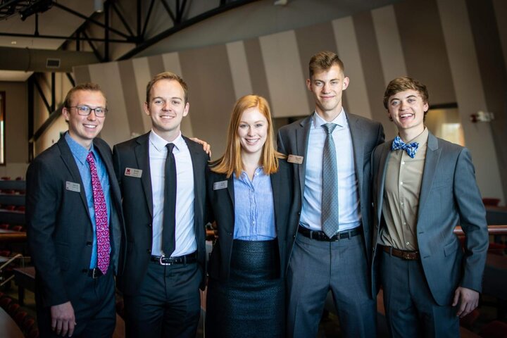 A group of people in suits standing together for a photograph.