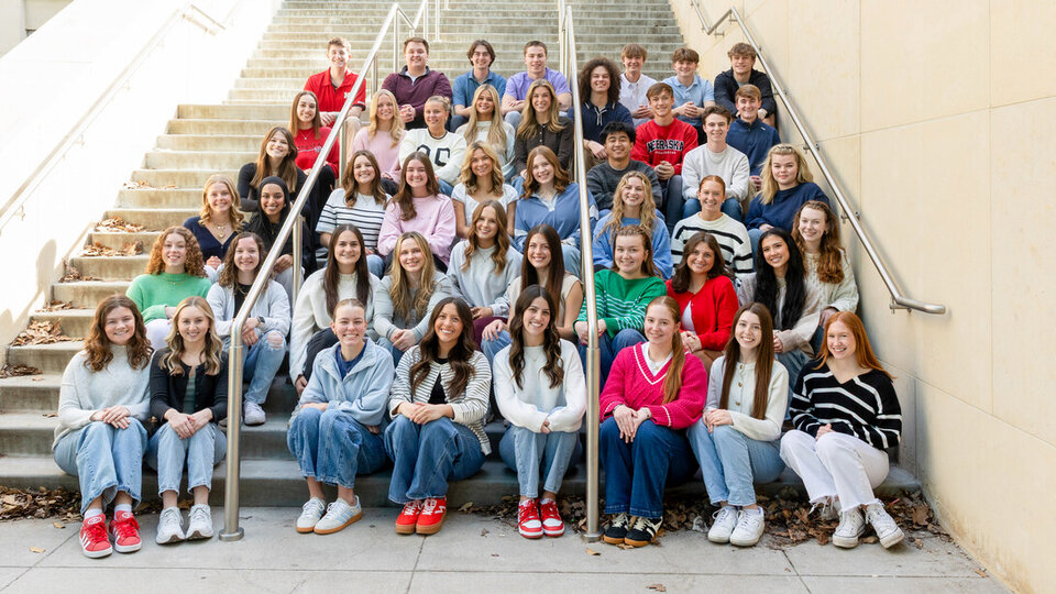 Forty-five students sit on an outdoor staircase.