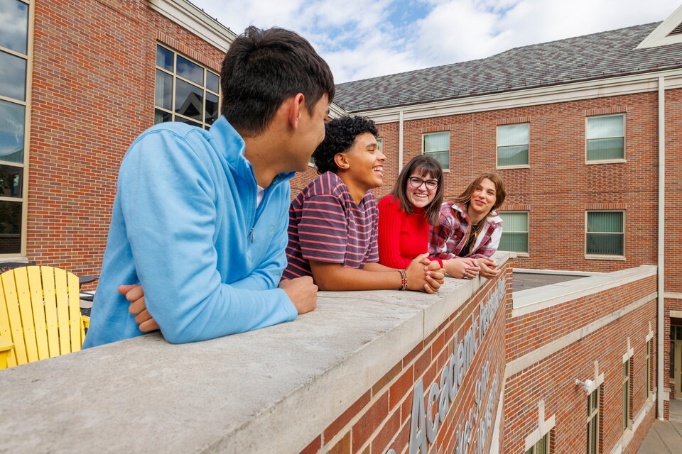 Four students on the balcony of Kauffman